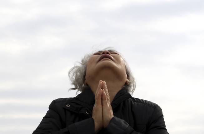 A weeping relative of a passenger aboard the sunken Sewol ferry prays as she awaits news on her missing loved one at a port in Jindo, South Korea, Tuesday, April 22, 2014.