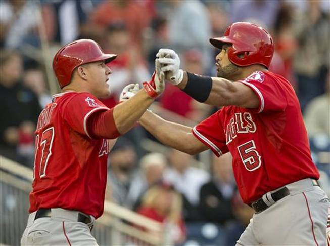 Los Angeles Angels Albert Pujols, right, is congratulated by teammate Mike Trout, left, after hitting a three-run homer off Washington Nationals starting pitcher Taylor Jordan during the first inning of a baseball game in Washington, Tuesday, April 22, 2014. It was Pujols 499th home run of his career. Later in the game, Pujols added his 500th-career home run.