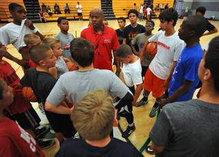 Former UNLV Runnin' Rebels point guard Dedan Thomas, center, instructs members of his youth team during a practice session held at Western Tech High School on Tuesday, April 22, 2014.