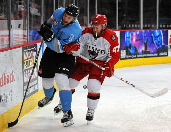 Las Vegas Wranglers forward Cody Purves (47) checks Alaska Aces defenseman James Martin into the boards behind the Aces net during the third period of play Wednesday, April 23, 2014, at Orleans Arena.