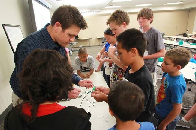 Jake Seifman helps Tama Salima build an electromagnet during "Take Our Daughters and Sons to Work Day" at NV Energy Thursday, April 24, 2014.