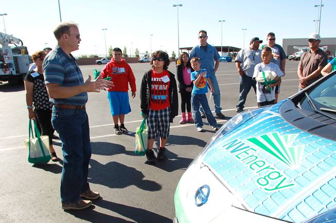 Todd Seibert talks about an electric car during "Take Our Daughters and Sons to Work Day" at NV Energy Thursday, April 24, 2014.