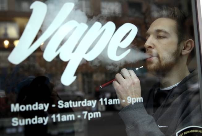 Eric Scheman demonstrates an e-cigarette at Vape store in Chicago, Wednesday, April 23, 2014. The federal government wants to ban sales of electronic cigarettes to minors and require approval for new products and health warning labels under regulations being proposed by the Food and Drug Administration.