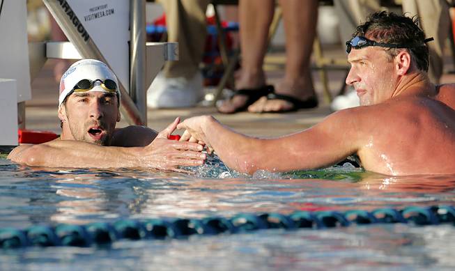 Michael Phelps congratulates Ryan Lochte on Lochte's win in the 100-meter butterfly final during the Arena Grand Prix on Thursday, April 24, 2014, in Mesa, Ariz. 