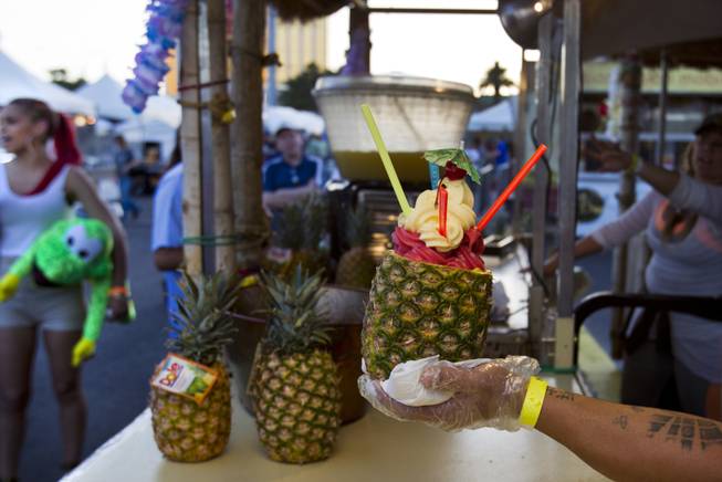 Another Ultimate Dole Whip Pineapple from Island Time Floats is handed to a customer during the Third Annual Las Vegas Foodie Fest across from the Luxor Hotel on Thursday, April 24, 2014.