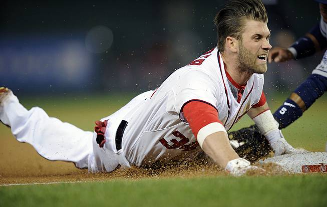 Washington Nationals left fielder Bryce Harper slides into third with a three-RBI triple during the third inning of a baseball game against the San Diego Padres, Friday, April 25, 2014, in Washington. 


