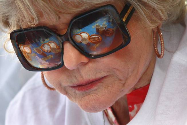 Empty plates are reflected in the glasses of Carlene LeFevre  during qualifying for Nathan's Famous Fourth of July Hot Dog Eating Contest Saturday, April 26, 2014 at New York New York. LeFevre placed first in the women't division and will compete for a national title on July 4th in New York.