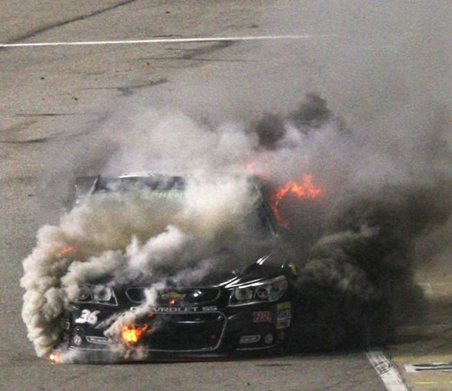 Reed Sorenson's car burns on pit row during the NASCAR Sprint Cup auto race at Richmond International Raceway in Richmond, Va., Saturday April 26, 2014. 