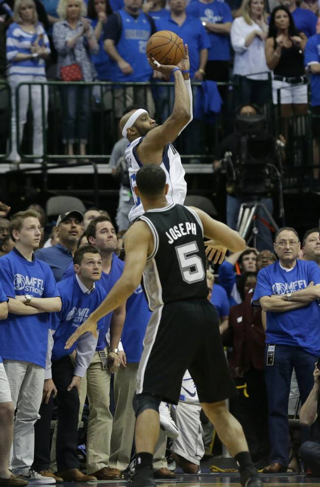 Dallas Mavericks guard Vince Carter, top, shoots the game-winning 3-point basket at the buzzer over San Antonio Spurs guard Cory Joseph (5) in the fourth quarter of Game 3 in the first round of the NBA basketball playoffs in Dallas, Saturday, April 26, 2014. The Mavericks won 109-108.
