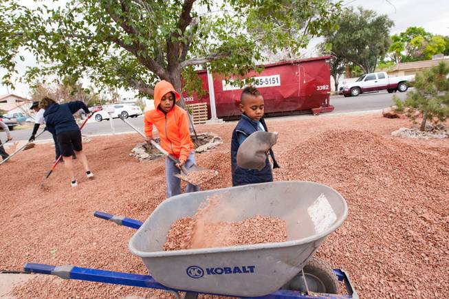 Brothers TJ Hinton, 7, and Thunder, 5 (right), shovel decorative landscaping rocks while volunteering at the home of photographer Robert Scott Hooper and wife Theresa Hooper as part of the Rebuilding Together Southern Nevada's annual neighborhood rebuilding event Saturday, April 26, 2014.