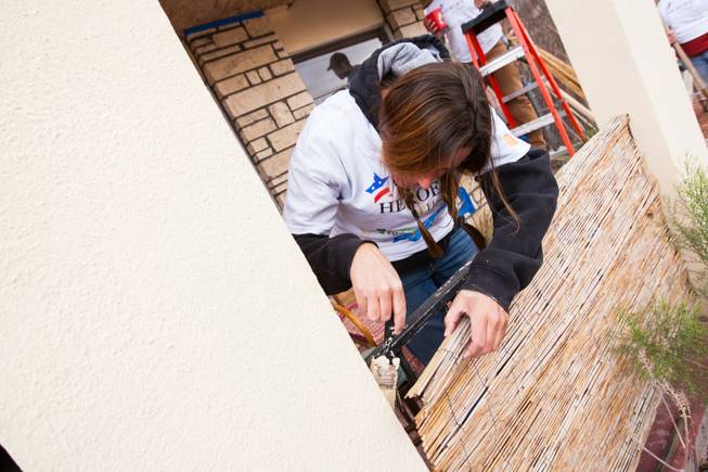 A volunteer cuts the edges with paint on the front porch of the home of photographer Robert Scott Hooper and wife Theresa Hooper as part of the Rebuilding Together Southern Nevada's annual neighborhood rebuilding event in Las Vegas Saturday, April 26, 2014.