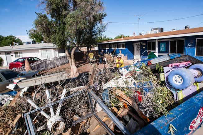 Volunteer Javier Echavarria tosses front yard debris into a dumpster of items removed from the home of former magician Gary Darwin, who lost his leg to diabetes, as part of the Rebuilding Together Southern Nevada's annual neighborhood rebuilding event in Las Vegas Saturday, April 26, 2014.