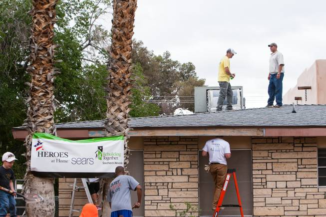 Volunteers inspect the roof of the home of photographer Robert Scott Hooper and wife Theresa Hooper as part of the Rebuilding Together Southern Nevada's annual neighborhood rebuilding event in Las Vegas Saturday, April 26, 2014.