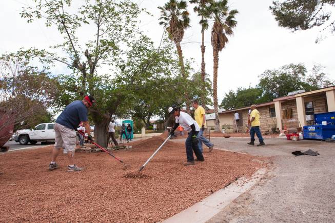 Volunteers work on the desert landscaping in the front yard of the home of photographer Robert Scott Hooper and wife Theresa Hooper as part of the Rebuilding Together Southern Nevada's annual neighborhood rebuilding event Saturday, April 26, 2014.
