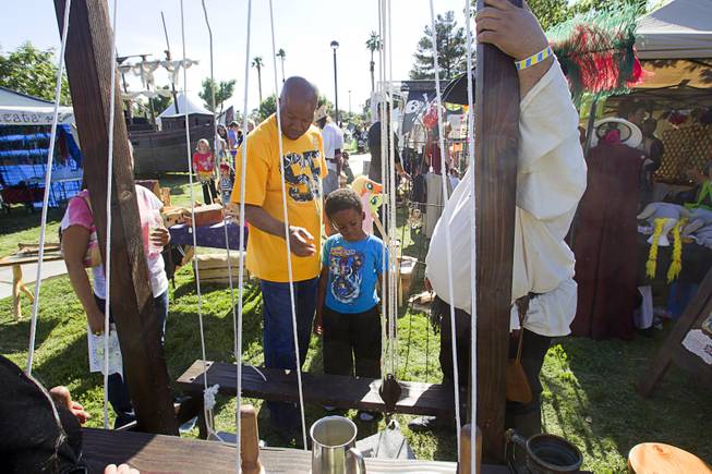 Lonnie Cureton and his son Donald, 5, learn about rigging during the second annual Pirate Festival Las Vegas in Lorenzi Park Sunday, April 27, 2014.