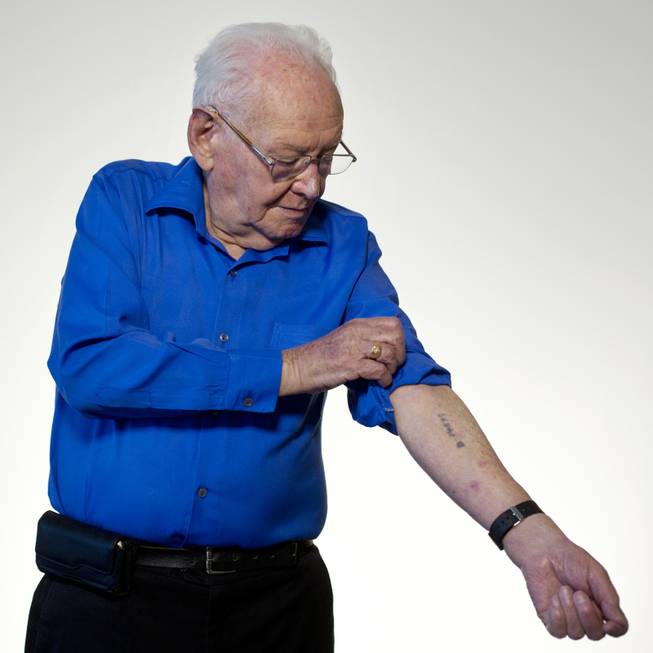 Israeli Holocaust survivor Asher Aud (Sieradski), 86, originally from Poland, shows his number tattooed on his arm by the Nazis at the Auschwitz concentration camp as he poses for a portrait in Jerusalem. Of all the atrocities he endured, Aud said the strongest memory is the one that was most traumatic — parting from his mother at the age of 14.