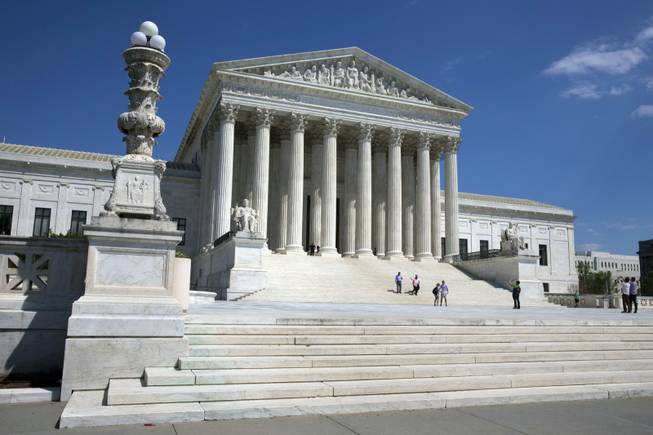 People walk on the steps of the U.S. Supreme Court in Washington. Two Supreme Court cases about police searches of cellphones without warrants present vastly different views of the ubiquitous device. Is it a critical tool for a criminal or is it an American’s virtual home? How the justices answer that question could determine the outcome of the cases being argued Tuesday, April 29, 2014. A drug dealer and a gang member want the court to rule that the searches of their cellphones after their arrest violated their right to privacy in the digital age. 