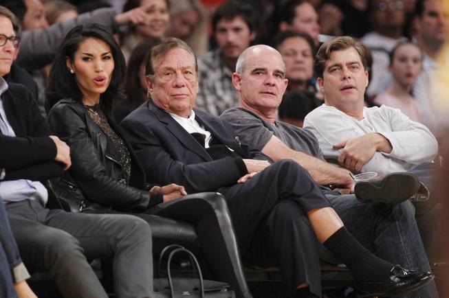 Los Angeles Clippers owner Donald Sterling, right, and V. Stiviano, left, watch the Clippers play the Los Angeles Lakers during an NBA preseason basketball game in Los Angeles on Monday, Dec. 19, 2011.