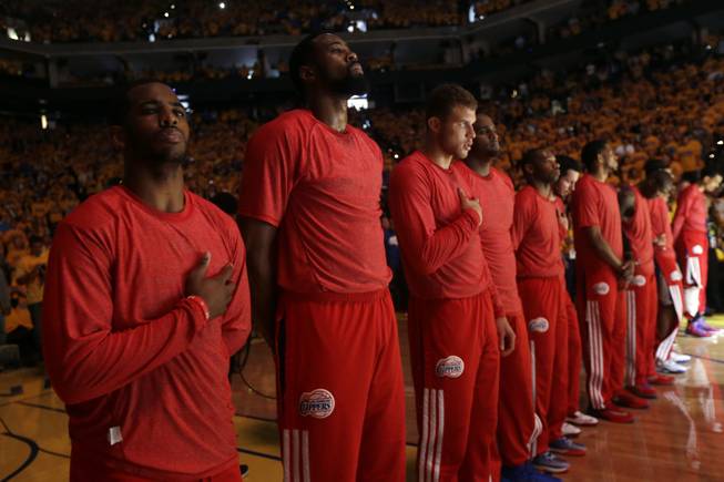 Los Angeles Clippers players listen to the national anthem wearing their warmup jerseys inside out to protest alleged racial remarks by team owner Donald Sterling before Game 4 of an opening-round NBA basketball playoff series against the Golden State Warriors on Sunday, April 27, 2014, in Oakland, Calif.