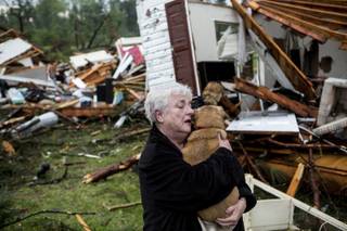 Constance Lambert embraces her dog after finding it alive when returning to her destroyed home in Tupelo, Miss., Monday, April 28, 2014. Lambert was at an event away from her home when the tornado struck and rushed back to check on her pets. 