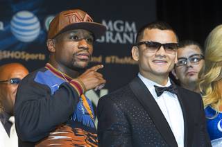 WBC welterweight champion Floyd Mayweather Jr., left, and WBA champion Marcos Maidana of Argentina pose during a news conference at the MGM Grand Wednesday, April 30, 2014. The two champions will meet in a WBC/WBA unification fight at the MGM Grand Garden Arena on Saturday.