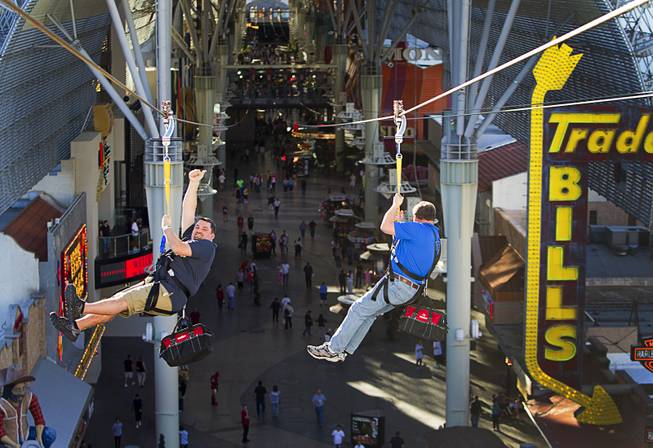 Russ Dostal (L) gives a thumbs up as he tries the new 850-feet-long SlotZilla Zipline with Tom Delaney at the Fremont Street Experience in downtown Las Vegas, Wednesday, April 30, 2014. A higher and longer 1700-feet-long Zoomline, which will propel flyers in a horizontal "superman" position at speeds up to 35 mph, is expected to open in June. The zip-line, part of the $12 million SlotZilla project, opened Sunday.