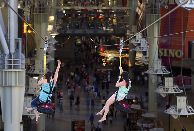 A pair of tourists from Tennesee try out the new 850-feet-long SlotZilla Zipline at the Fremont Street Experience in downtown Las Vegas, Wednesday, April 30, 2014. A higher and longer 1700-feet-long Zoomline, which will propel flyers in a horizontal "superman" position at speeds up to 35 mph, is expected to open in June. The zip-line, part of the $12 million SlotZilla project, opened April 27, 2014.