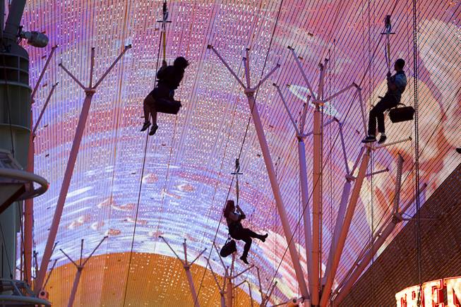People pass under the Viva Vision canopy as they try out the  new 850-feet-long SlotZilla Zipline at the Fremont Street Experience in downtown Las Vegas, Wednesday, April 30, 2014. A higher and longer 1700-feet-long Zoomline, which will propel flyers in a horizontal "superman" position at speeds up to 35 mph, is expected to open in June. The zip-line, part of the $12 million SlotZilla project, opened Sunday.