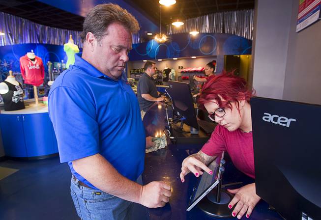 Ticket agent Kim Rush helps Tom Delaney of Saylorsburg, Penn. at the SlotZilla ticket office at the Fremont Street Experience in downtown Las Vegas, Wednesday, April 30, 2014. A 850-feet-long zip-line, part of the $12 million SlotZilla project, opened Sunday.