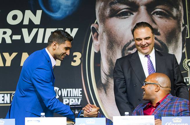 Welterweight boxer Amir Khan, left, of Britain greets Leonard Ellerbe, CEO of Mayweather Promotions, as Richard Schaefer, CEO of Golden Boy Promotions, looks on during a news conference for undercard boxers at the MGM Grand Thursday, May 1, 2014.