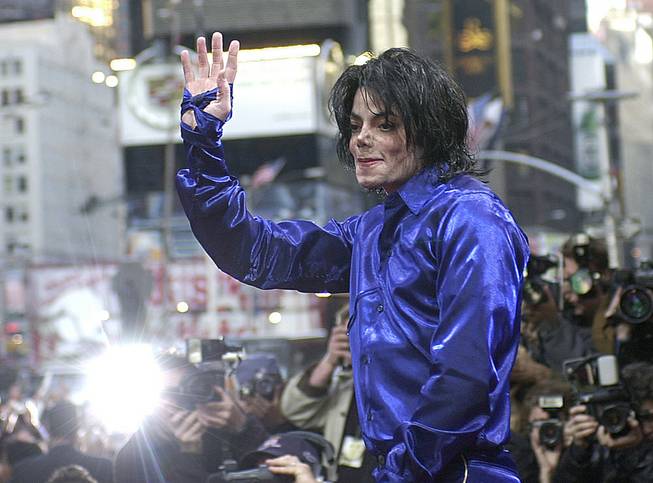 Michael Jackson waves to crowds gathered to see him at his first ever in-store appearance to celebrate his new album "Invincible" in New York's Times Square, Nov. 7, 2001. 
