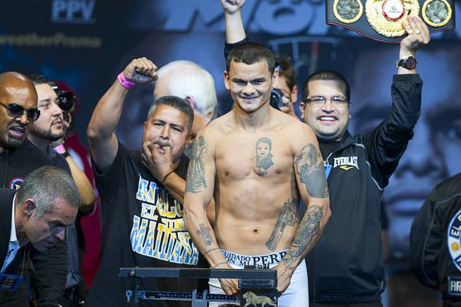 WBA welterweight champion Marcos Maidana of Argentina poses on the scale during an official weigh-in at the MGM Grand Garden Arena Friday, May 2, 2014. Maidana faces WBC welterweight champion Floyd Mayweather Jr.  in a WBC/WBA unification fight at the arena on Saturday.