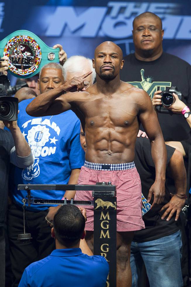 WBC welterweight champion Floyd Mayweather Jr.  poses on the scale during an official weigh-in at the MGM Grand Garden Arena Friday, May 2, 2014. Mayweather faces WBA welterweight champion Marcos Maidana of Argentina in a WBC/WBA unification fight at the arena on Saturday.