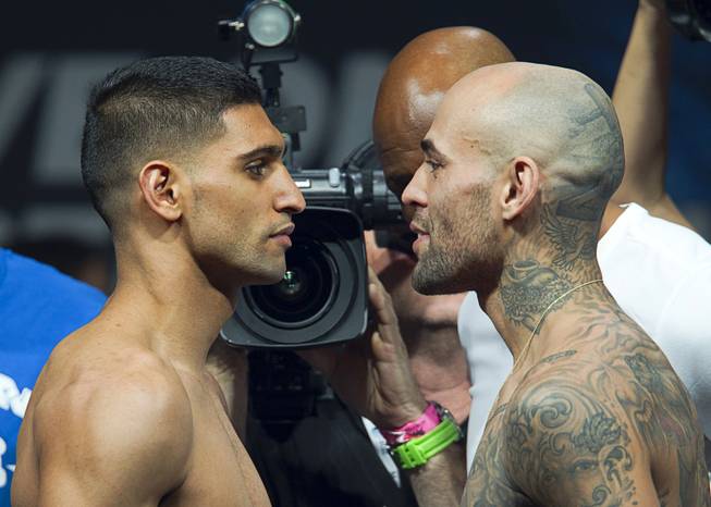 Amir Khan, left, of Britain and Luis Collazo face off during an official weigh-in at the MGM Grand Garden Arena Friday, May 2, 2014. The boxers will meet for a welterweight fight at the arena on Saturday.