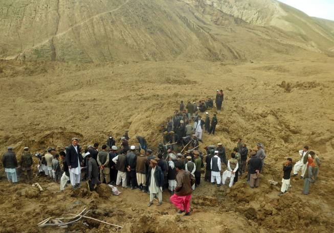 Afghans search for survivors after Friday's landslide buried Abi-Barik village in Badakhshan province, northeastern Afghanistan, Saturday, May 3, 2014. Afghan rescuers and hundreds of volunteers armed with shovels rushed on Saturday to help villagers hit by a massive landslide in the remote northeast a day earlier, officials said, while fears of a new torrent of mud and earth complicated rescue efforts.