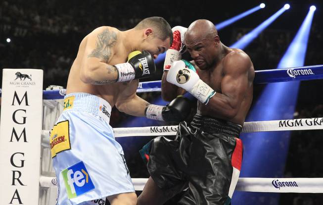 Marcos Maidana, left, of Argentina battles it out with Floyd Mayweather Jr. of the U.S. during their WBC/WBA welterweight unification fight at the MGM Grand Garden Arena on Saturday, May 3, 2014.