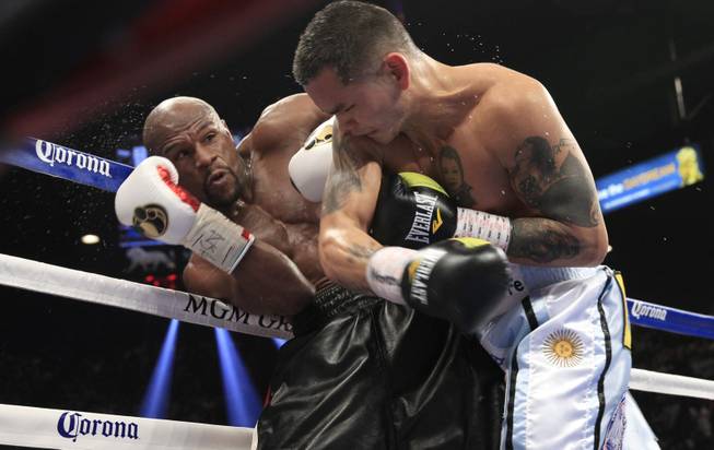 Floyd Mayweather Jr. of the U.S. avoids a punch from Marcos Maidana of Argentina during their WBC/WBA welterweight unification fight at the MGM Grand Garden Arena on Saturday, May 3, 2014.