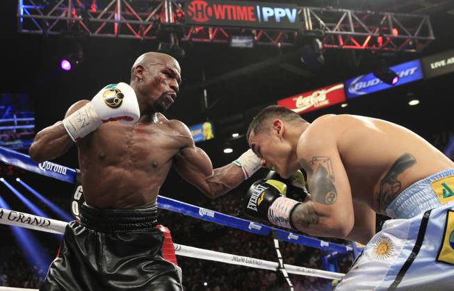 Floyd Mayweather Jr. of the U.S. punches at Marcos Maidana of Argentina during their WBC/WBA welterweight unification fight at the MGM Grand Garden Arena on Saturday, May 3, 2014.