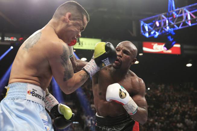 Marcos Maidana, left, of Argentina takes a punch from Floyd Mayweather Jr. of the U.S. during their WBC/WBA welterweight unification fight at the MGM Grand Garden Arena on Saturday, May 3, 2014.