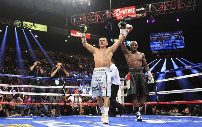 Marcos Maidana, left, of Argentina and Floyd Mayweather Jr. of the U.S. both celebrate after their WBC/WBA welterweight unification fight at the MGM Grand Garden Arena on Saturday, May 3, 2014.