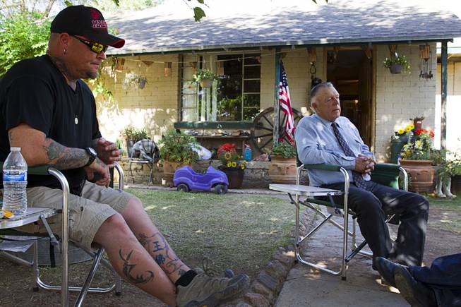 Booda (no last name provided) of Prescott, Ariz. sits by rancher Cliven Bundy during an interview at the Bundy ranch house near Bunkerville, Sunday, May 4, 2014.