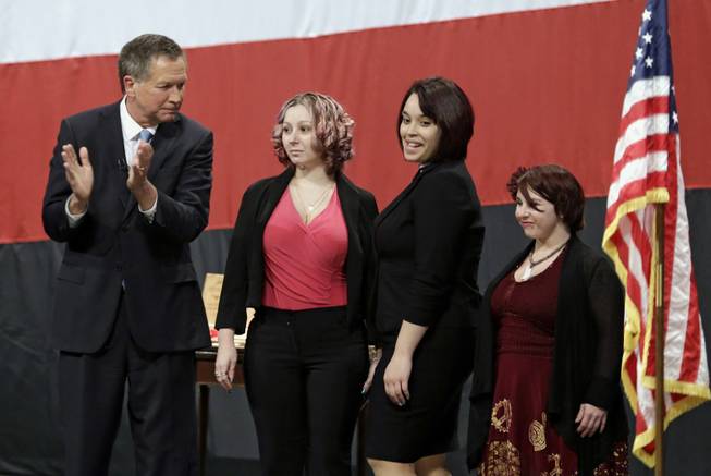 This Feb. 24, 2014, photo shows Ohio Gov. John Kasich introducing Amanda Berry, Gina DeJesus and Michelle Knight during his State of the State address at the Performing Arts Center in Medina, Ohio. Berry broke through a screen door to freedom last May. Upstairs, officers found DeJesus and Knight. They had been snatched off the streets separately between 2002 and 2004 and locked inside Ariel Castro’s house, where he chained and raped them, investigators later said. The list of missing people in Cleveland makes up about 1 out of every 10 cases in the entire state. Most are found within a few weeks, but there are more than 22 people who have been gone for more than a year.