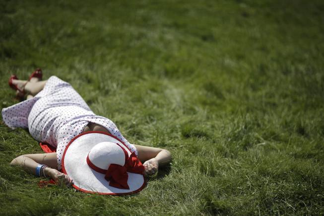 Jaclyn Linde of Madison, Wis. lays in the sun before the 140th running of the Kentucky Derby horse race at Churchill Downs Saturday, May 3, 2014, in Louisville, Ky. 