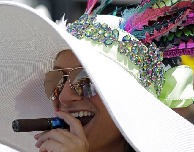 Nicole Finch smoke a cigar before the 140th running of the Kentucky Derby horse race at Churchill Downs Saturday, May 3, 2014, in Louisville, Ky. 