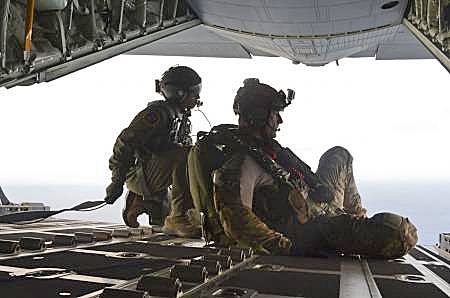 In this May 3, 2014, image provided by the U.S. Air Force, Airman 1st Class Franscisco Harper, left, and a pararescue Airman survey the area as U.S. Air Force pararescue forces parachute into the Pacific Ocean to aid to two critically injured sailors aboard a Venezuelan fishing boat. 