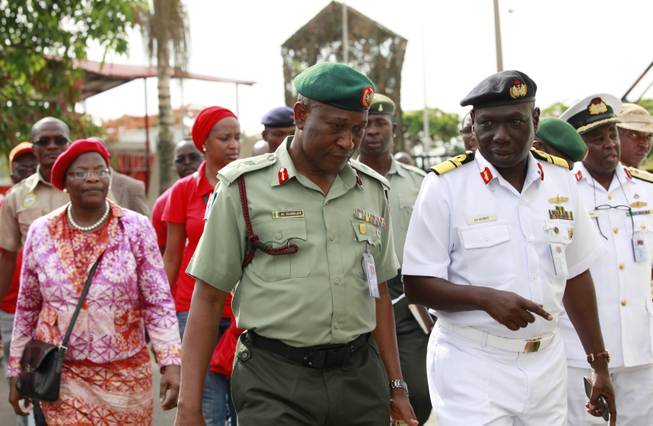 Brig. Gen. Chris Olukolade, Nigeria's top military spokesman, centre, walks with representatives of  kidnapped schoolgirls of Chibok secondary school, for a meeting at the defense  headquarters, in Abuja, Nigeria, Tuesday, May 6, 2014.  