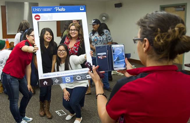 Students take a photo with a photo frame during "Paws" for a Study Break at UNLV's Lied Library Wednesday, May 7, 2014. The library sponsored the second annual study break with certified therapy dogs from Love Dog Adventures to help calm students stressing over final exams.