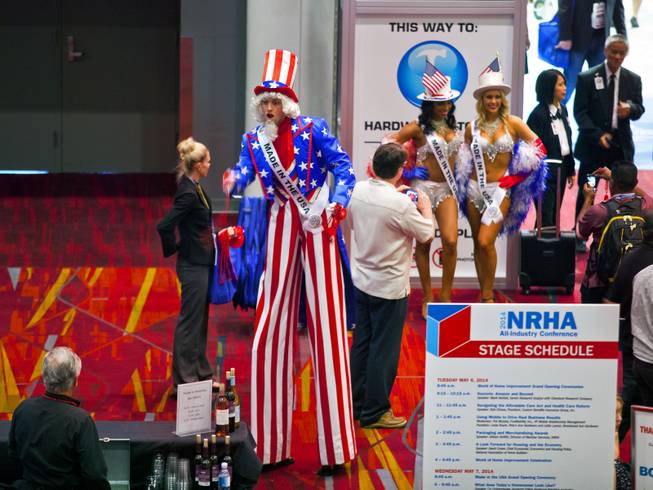 An Uncle Sam on stilts passes out necklaces to attendees about an entrance to the National Hardware Show 2014 in the Las Vegas Convention Center on Wednesday, May 7, 2014.   L.E. Baskow