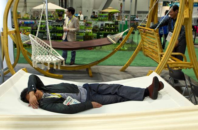 A representative of Xuzhou Lijun Crafts, Co., LTD., takes a nap on one of their hammocks on display at the National Hardware Show 2014 in the Las Vegas Convention Center on Wednesday, May 7, 2014.   L.E. Baskow