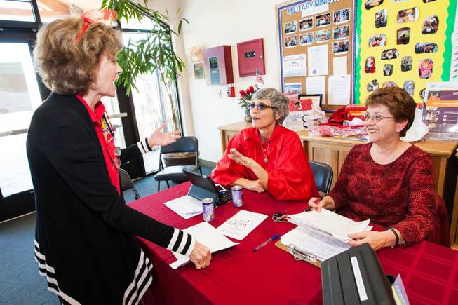 GriefShare facilitator Carol Von Eschen, center, laughs with volunteers Kitty Metzger and Brenda Wendling, right, while working the booth during the blood drive at New Song Church in Henderson Sunday, April 6, 2014.